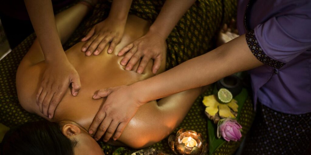 Two professional therapists performing a synchronized four hand massage in Gulshan 2