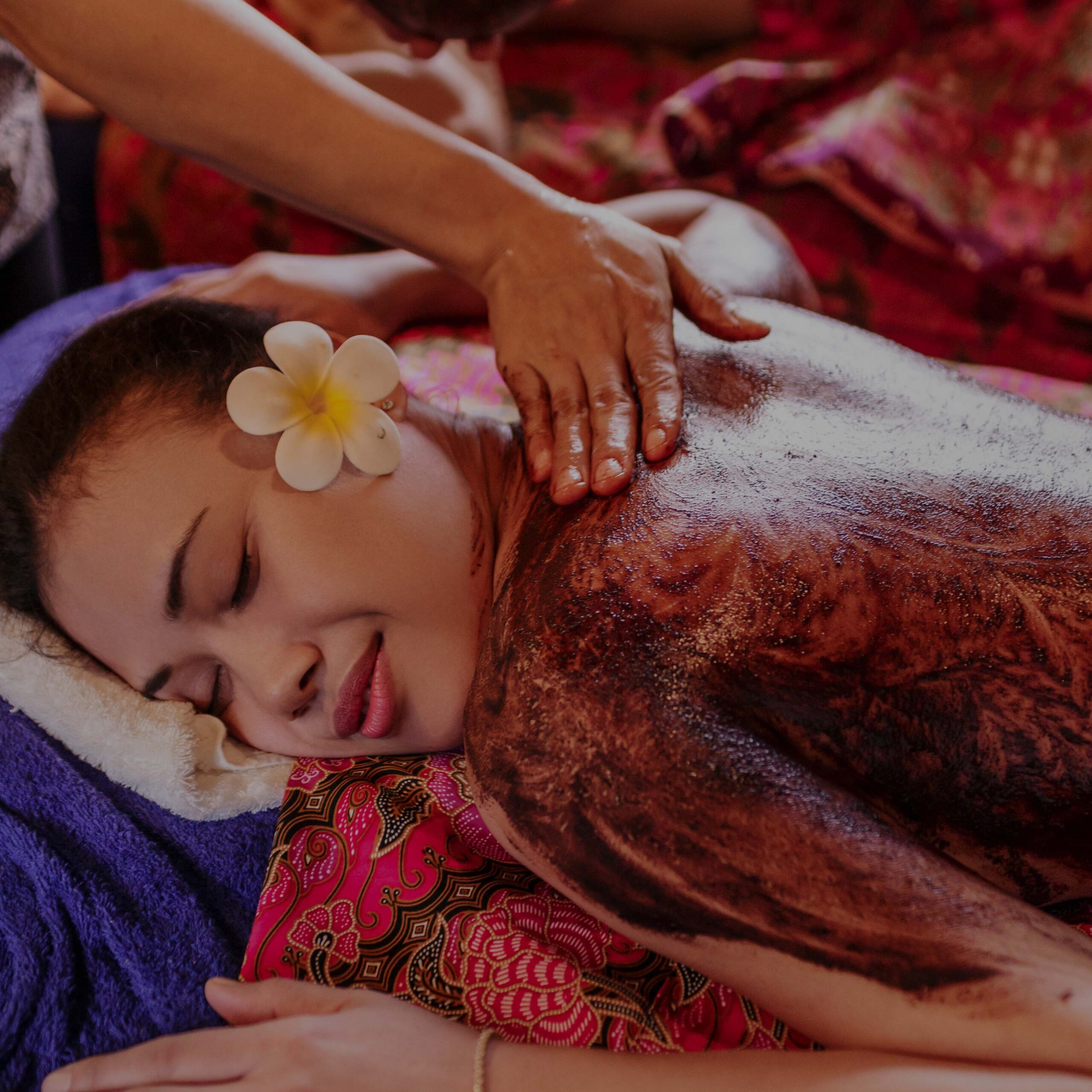 therapist applying an exfoliating body scrub treatment to a client at a spa therapist applying an exfoliating body scrub treatment to a client at a spa